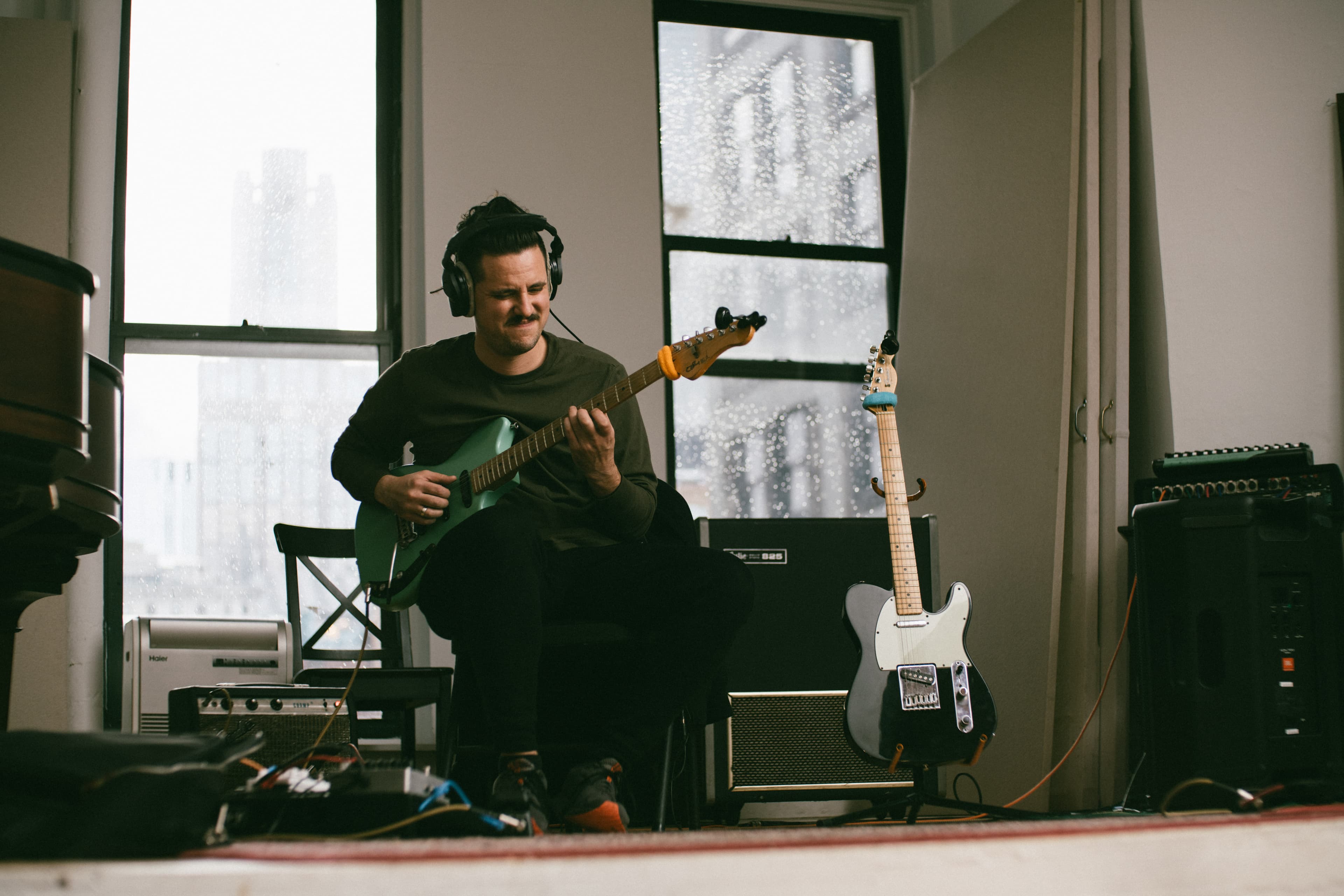 Rami Atassi playing guitar in his studio